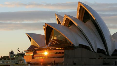 This recent photo shows a sunrise over one of the world's greatest tourism icons, the Sydney Opera House. The Opera House, the busiest performing arts centre in the world was designed by Danish architect Jorn Utzon and has 6,225 sq m (67,000 sq ft) of French made glass in the mouths of the roofs and other areas, officially opening on 20 October 1973 and has helped make Australia a must-see international destination for tourists.  AFP PHOTO/Greg WOOD        (Photo credit should read GREG WOOD/AFP/Getty Images)