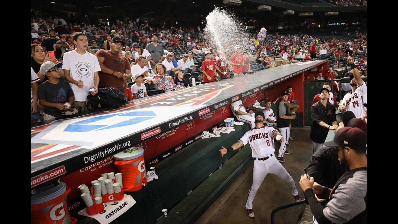 Arizona's David Peralta playfully throws water from the dugout in Phoenix before the start of a game on Wednesday, June 28.