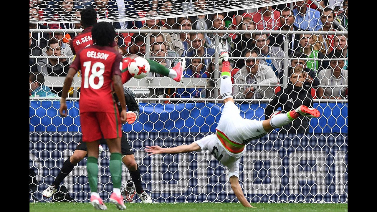 Mexican forward Oribe Peralta falls over as his shot is blocked by Portugal's Nelson Semedo on Sunday, July 2. Portugal won 2-1 to claim third place in the Confederations Cup.