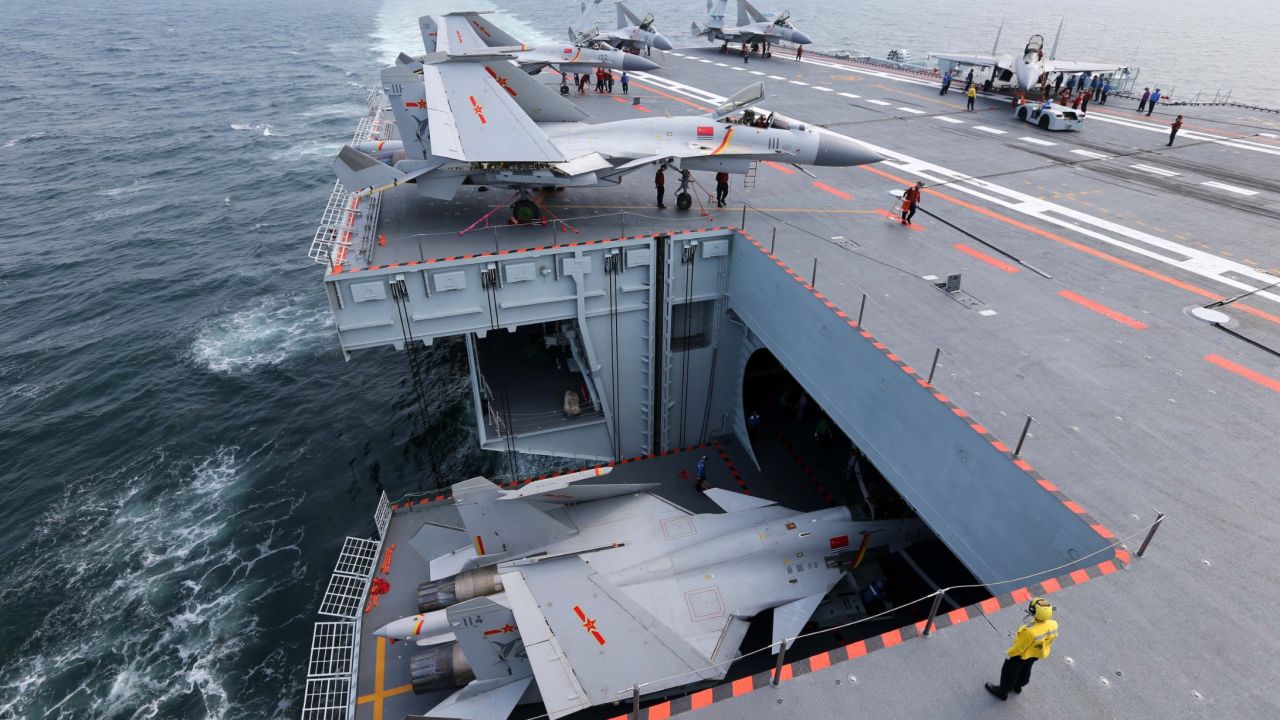 Sailors transfer a J-15 fighter jet into the hangar bay during a training exercise on July 1.