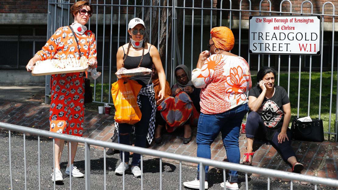 People arrive with trays of food for people evacuated from their properties, close to Grenfell Tower, on June 14.