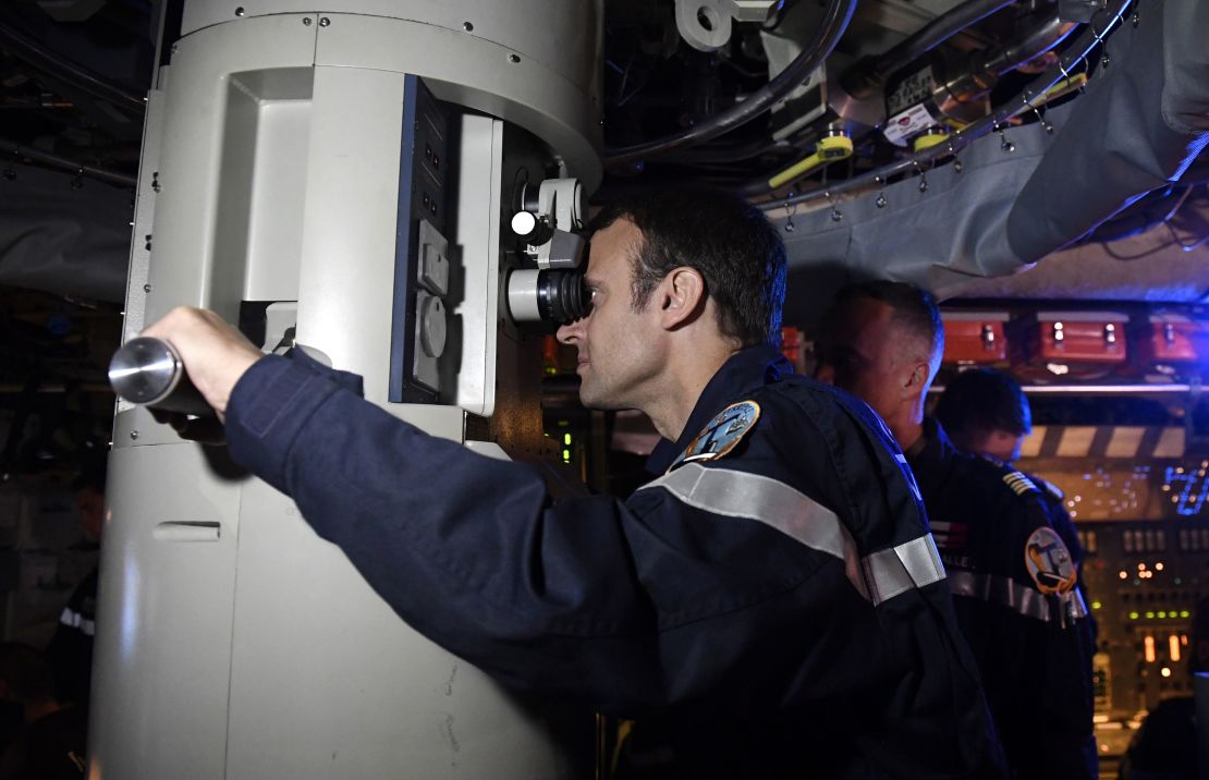 French President Emmanuel Macron looks through the periscope of submarine "Le Terrible" during a July 4, 2017 visit aboard the vessel. 