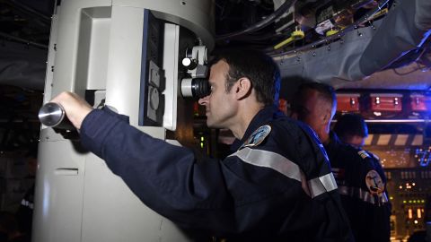 French President Emmanuel Macron looks through the periscope of submarine "Le Terrible" during a July 4, 2017 visit aboard the vessel. 
