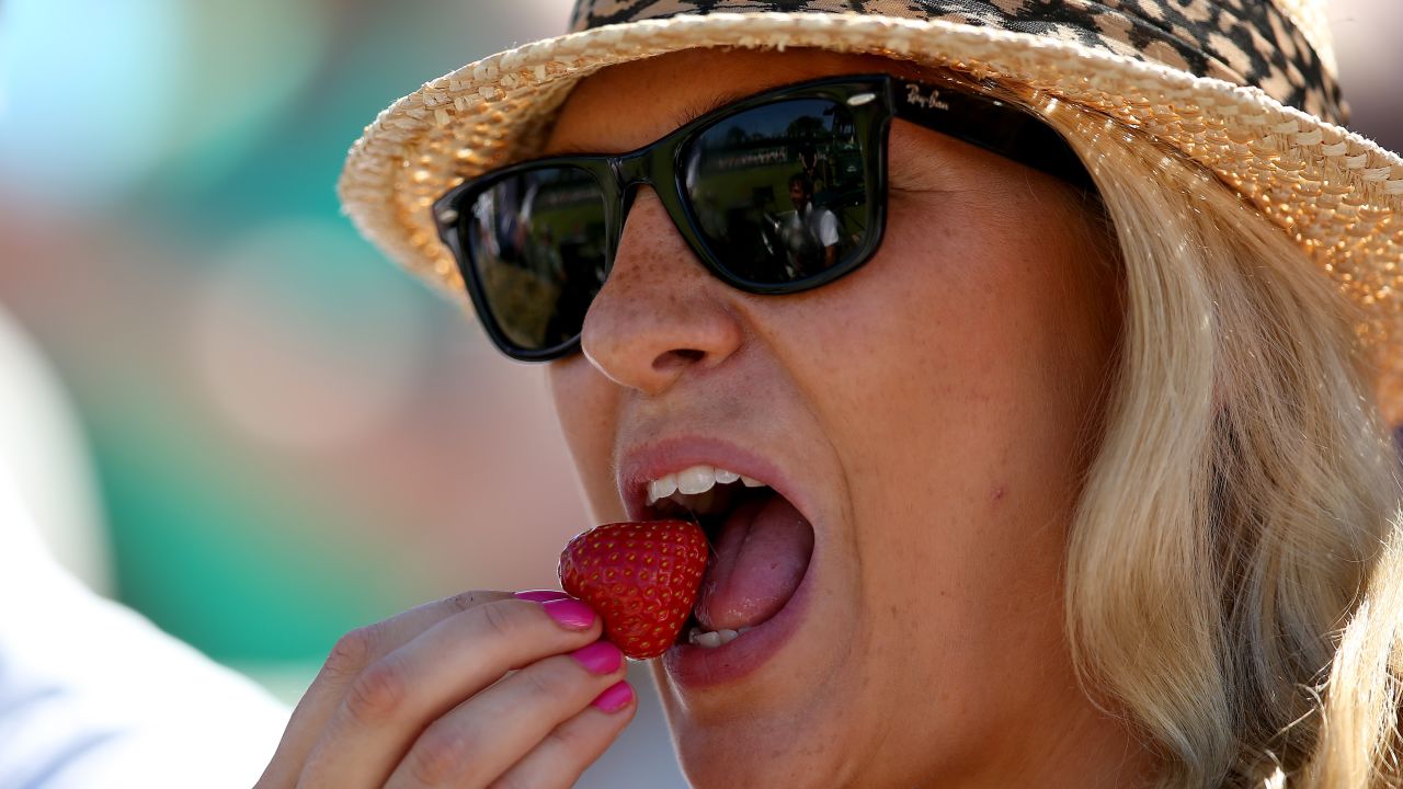 Spectator eats a strawberry during Wimbledon 