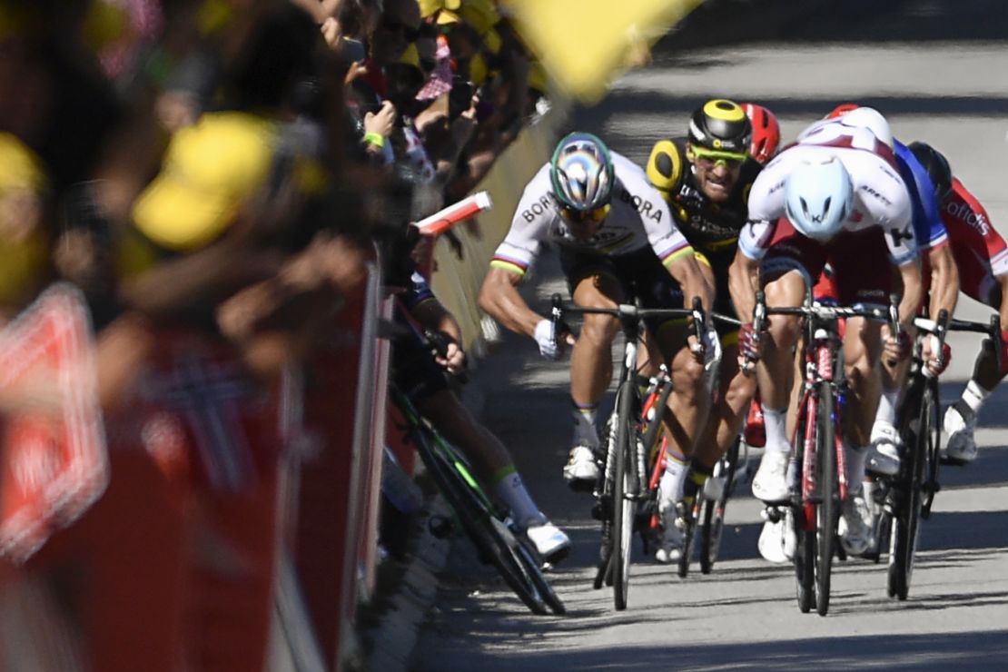 Sagan gives a kick of his elbow and Cavendish (L) falls near the finish line of stage four.