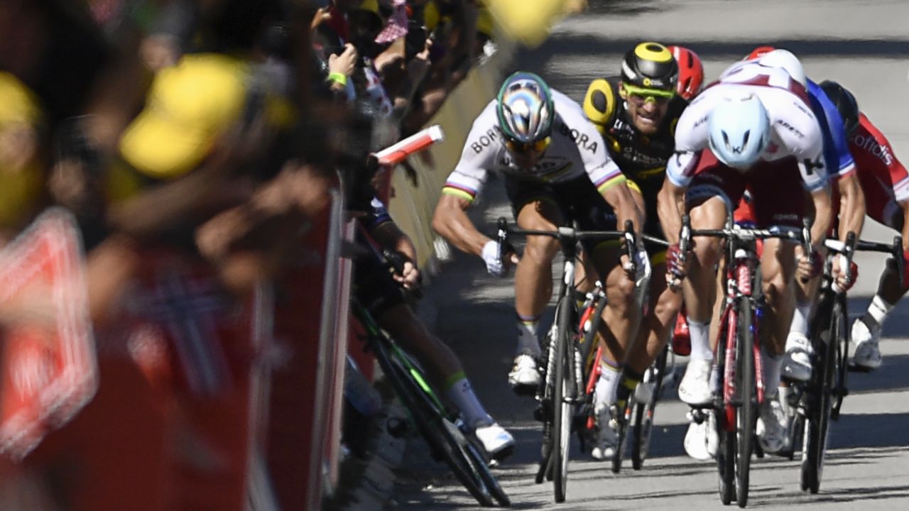 Sagan gives a kick of his elbow and Cavendish (L) falls near the finish line of stage four.