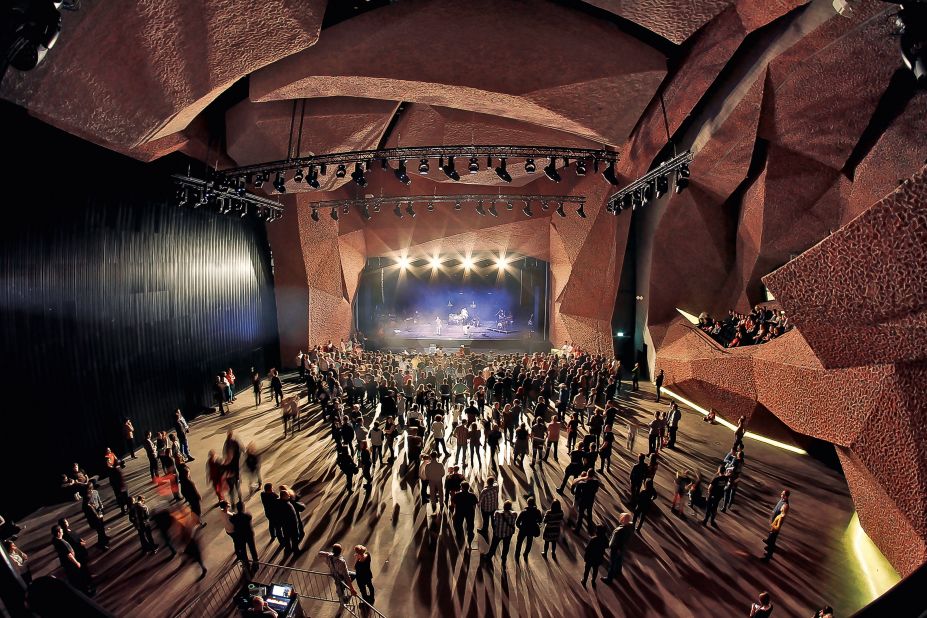 An intimate gig takes place under an umbrella of red brick at the CKK Jordanki Congress and Cultural Center in Torun, Poland. This building takes brick laying to the extreme by using crushed bricks and concrete to create the effect you see inside the building. 