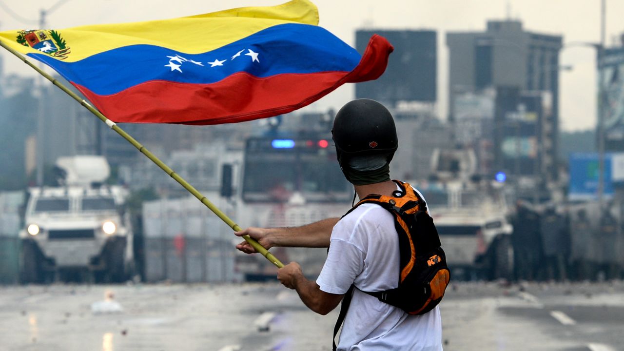 A Venezuelan opposition demonstrator waves a flag during a protest in May.