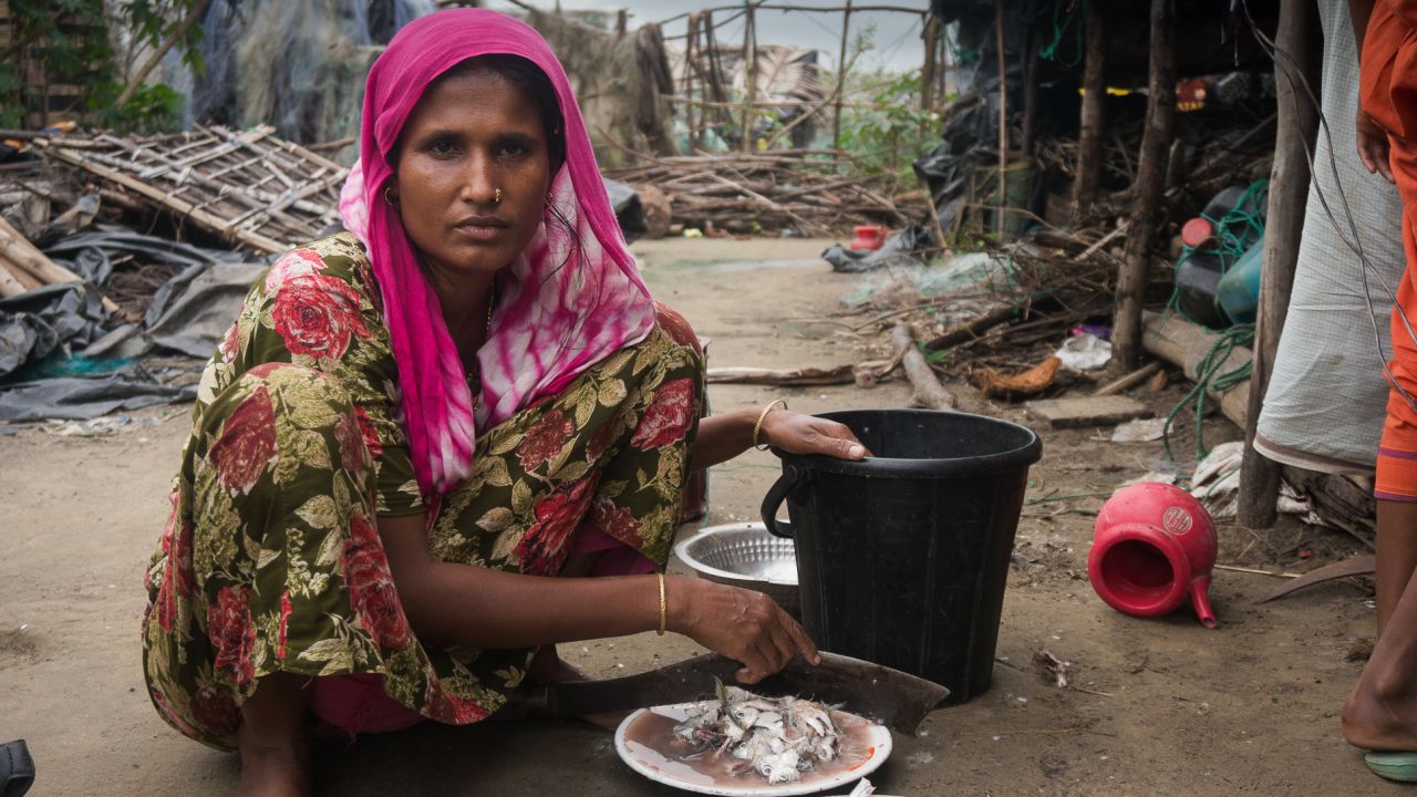 Hasna Akter prepares fish to feed her family in a rented shack in Cox's Bazar, Bangaldesh.