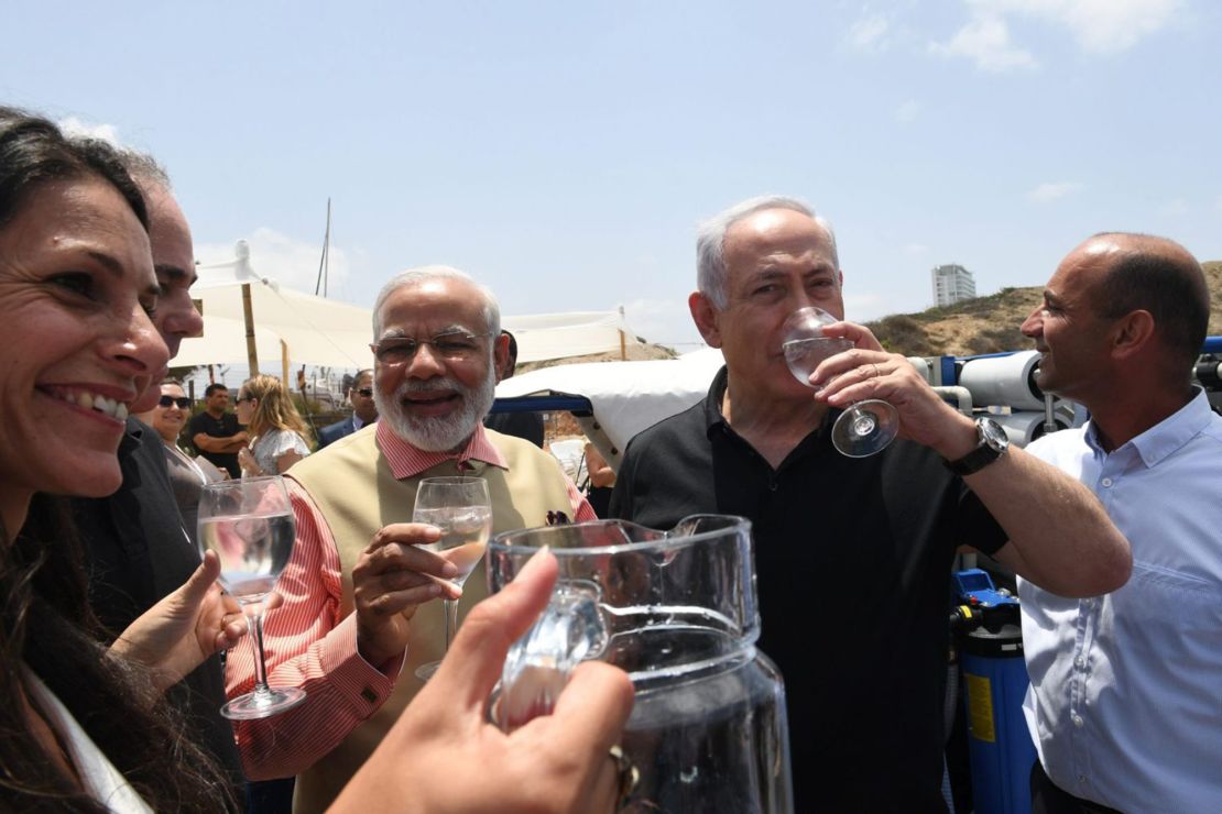 Indian Prime Minister Narendra Modi and Israeli Prime Minister Benjamin Netanyahu enjoy a glass of water during their visit to a mobile desalination unit.