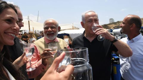 Indian Prime Minister Narendra Modi and Israeli Prime Minister Benjamin Netanyahu enjoy a glass of water during their visit to a mobile desalination unit.