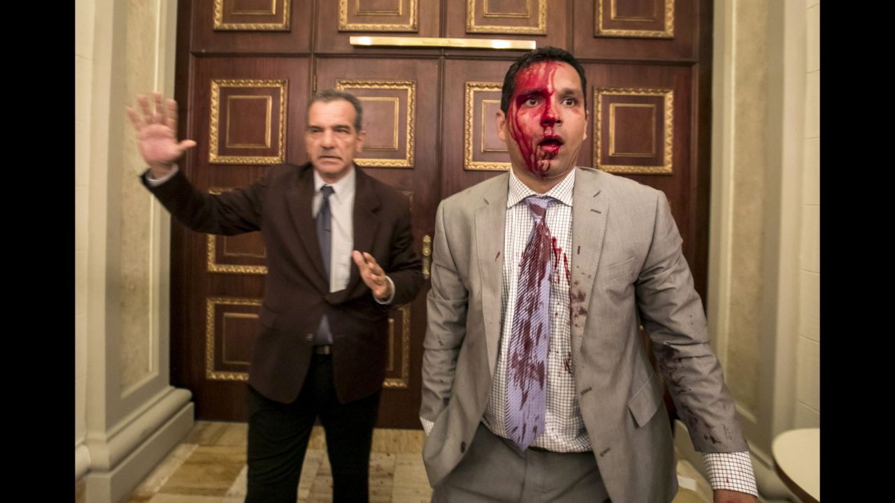 Venezuelan lawmakers Luis Stefanelli, left, and Jose Regnault stand in a corridor of the National Assembly after Wednesday's crash with demonstrators in Caracas.
