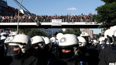 A banner on a bridge reads "President Macri, Don't sell our Argentina." Officials said at least 76 police officers were hurt.