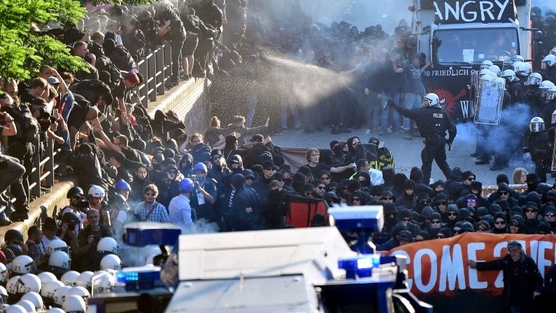 Police attempt to clear the street while using water cannons and pepper spray on demonstrators.