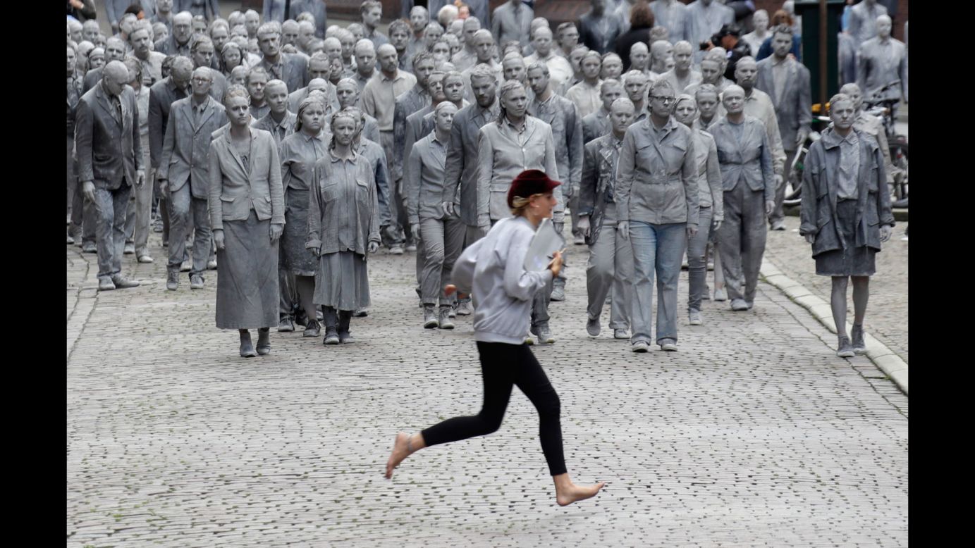 A woman crosses a street in Hamburg, Germany, in front of <a href="http://www.cnn.com/2017/07/06/europe/g20-zombies-protest/index.html" target="_blank">a performance piece</a> orchestrated by the 1,000 Gestalten (1,000 Figures) on Wednesday, July 5. The zombie-like participants were caked in dusty gray clay before a single demonstrator shed his facade to reveal colorful clothes beneath. Then others began to follow suit and do the same. Organizers wanted to emphasize their belief that change can start with one person. "We cannot wait until change happens from the world's most powerful, we have to show political and social responsibility -- all of us -- now!" a group spokesman said in a statement. Hamburg is hosting many world leaders this week for the G20 summit.