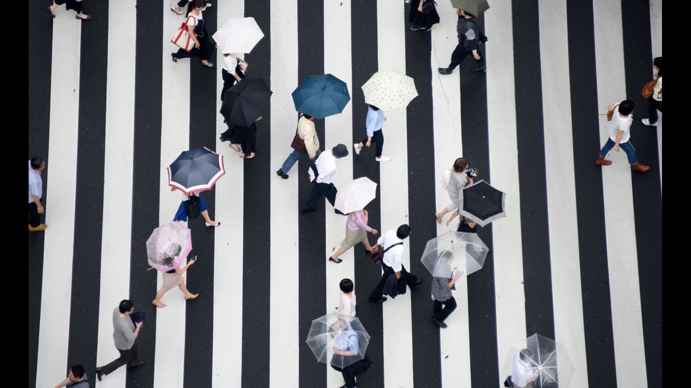 Pedestrians cross a street in Tokyo on Saturday, July 1.