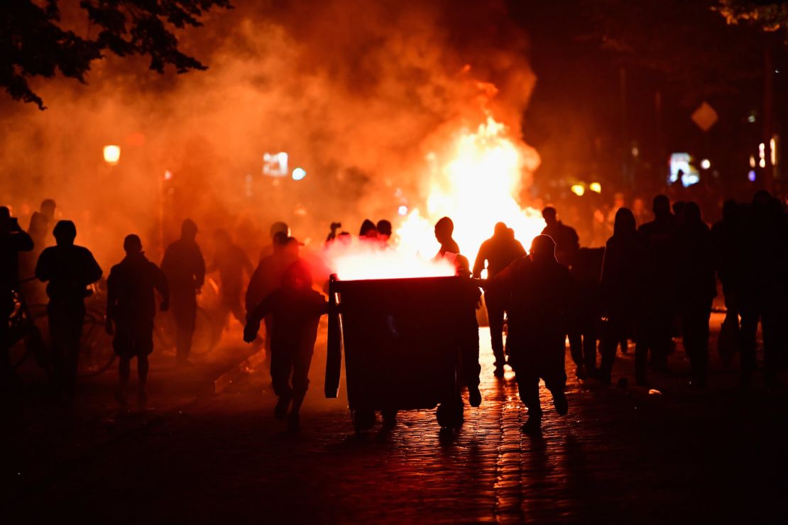Protesters set fire to items in the street near the Rote Flora left-wing center.