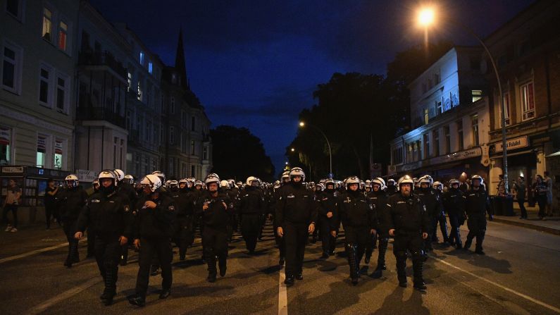 Riot police head down a road during the "Welcome to Hell" protest march on Thursday, July 6. 
