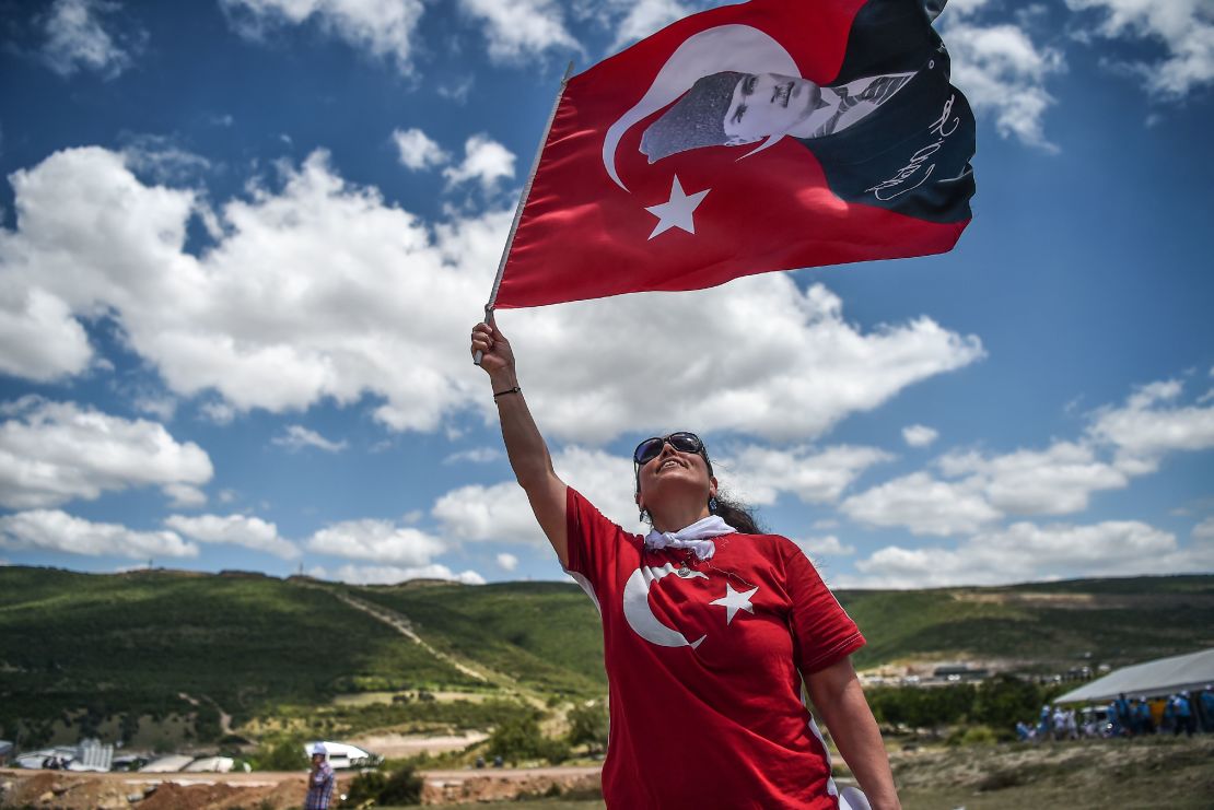 A protester waves a Turkish flag with the nation's founder, Mustafa Kemal Ataturk, superimposed on it. 