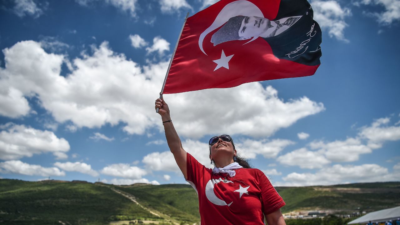 A protester waves a Turkish flag with the nation's founder, Mustafa Kemal Ataturk, superimposed on it.