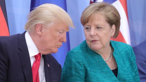 President Donald Trump and German Chancellor Angela Merkel attend a panel discussion Saturday. 