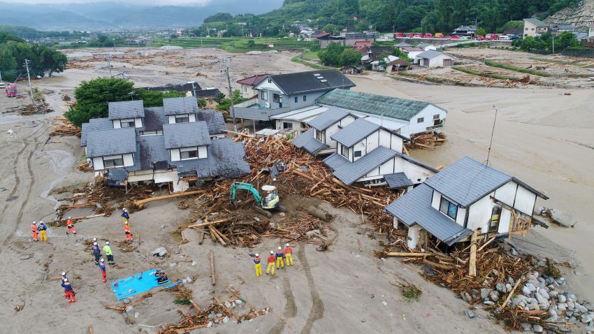 Firefighters inspect the collapsed houses in the mud following the flooding caused by heavy rain in Asakura, Fukuoka prefecture, southwestern Japan, Saturday, July 8, 2017.