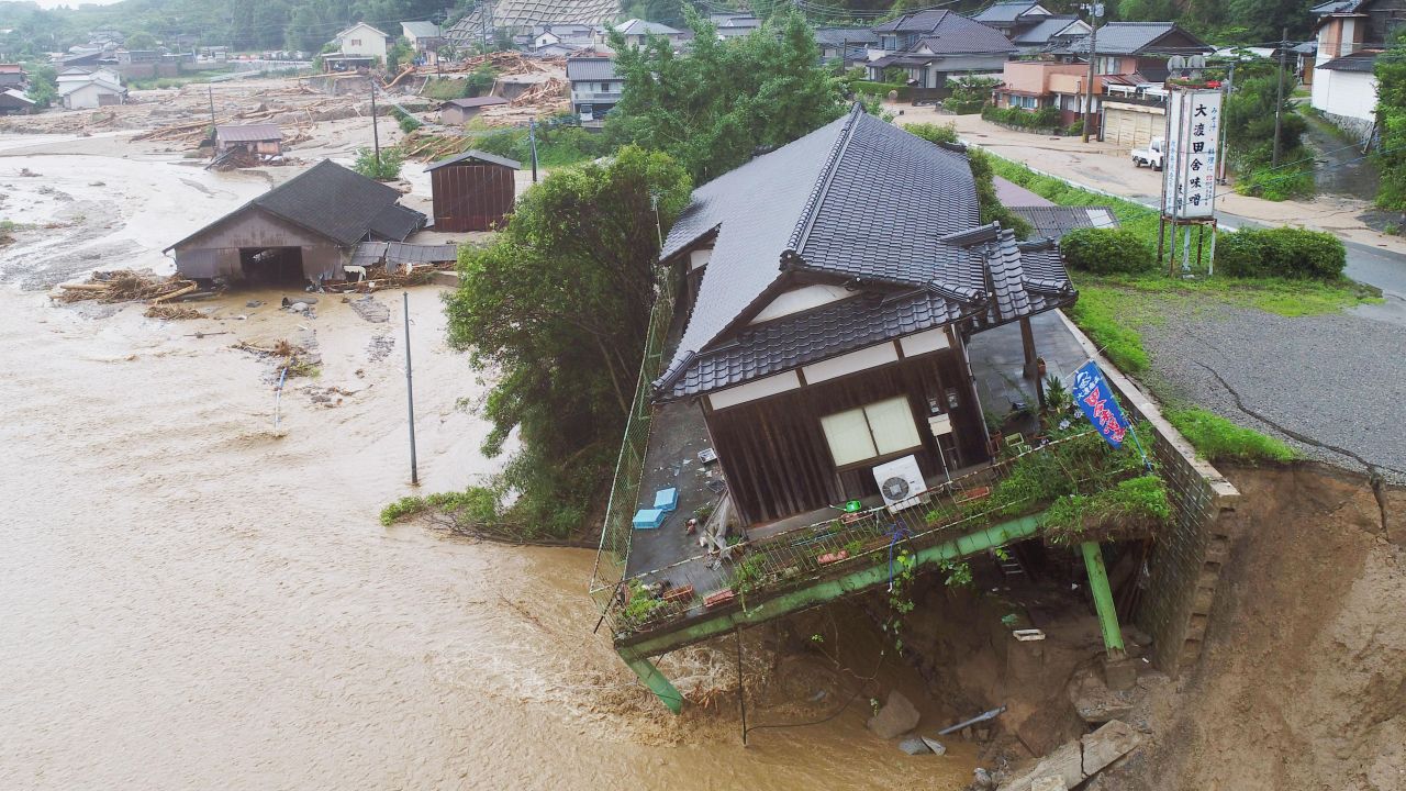A house tilts off the side of the road in flood and landslide-stricken Asakura in southwest Japan.