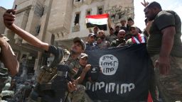 Members of the Iraqi interior ministry forces pose for a picture with an upside down Islamic State (IS) group flag in the Old City of Mosul on July 8, 2017, as their part of the battle has been declared accomplished, while other forces continue to fight the jihadists in the city.  AHMAD AL-RUBAYE/AFP/Getty Images