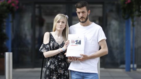Parents Connie Yates and Chris Gard pose with a petition of signatures supporting their case.