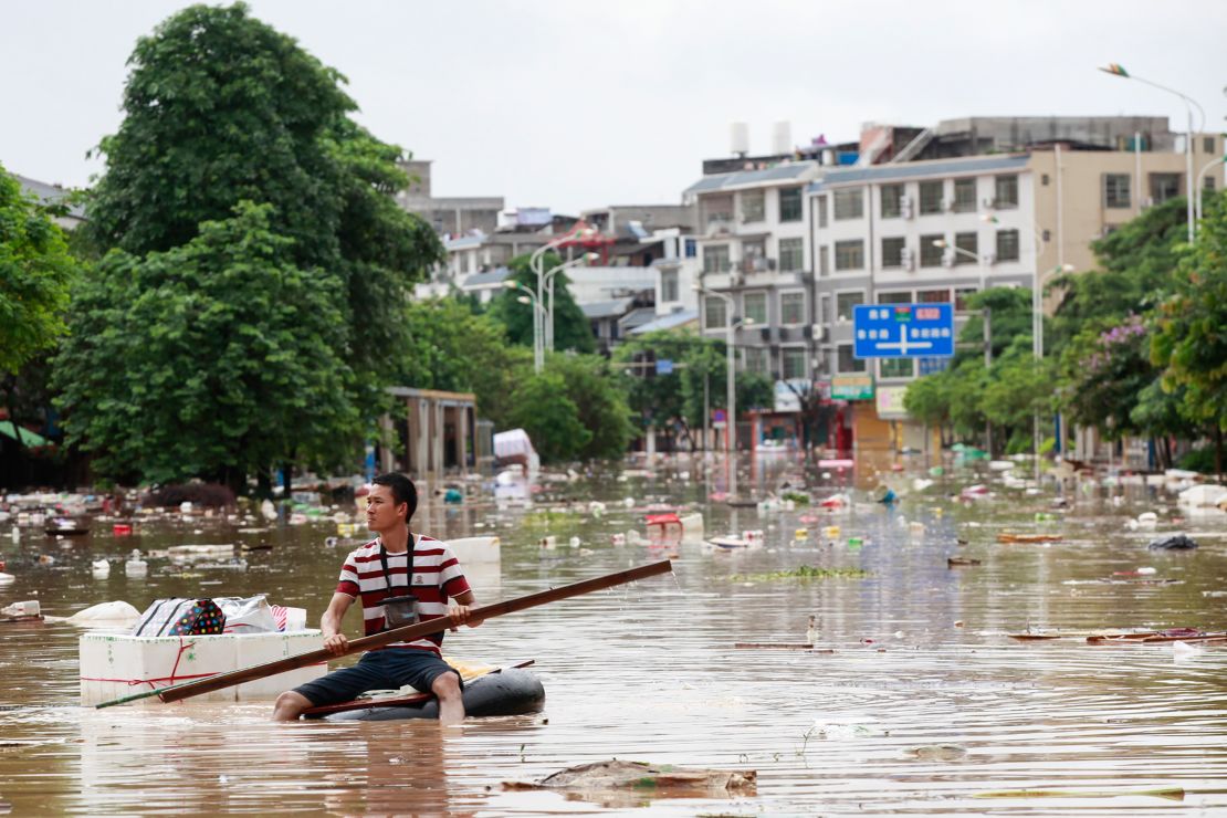 A man using an improvised flotation device in floodwaters in Liuzhou, Guangxi in July 2017.