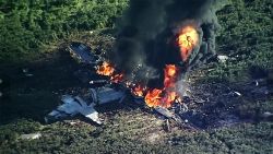 In this Monday, July 10, 2017 frame from video, smoke and flames rise from a military plane that crashed in a farm field, in Itta Bena, Miss., killing several. (WLBT-TV via AP)