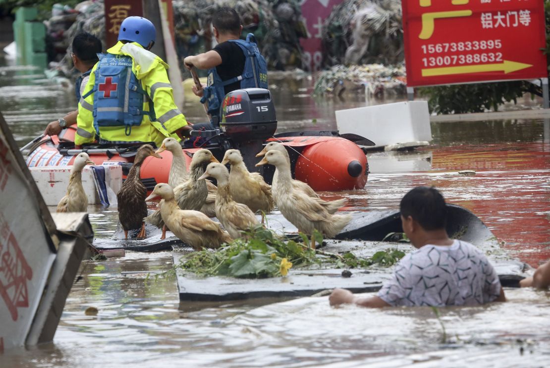 Rescue workers helping people on a flooded street in Loudi, Hunan province, in July 2017.
