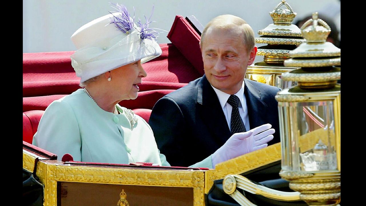 Putin leaves in an open carriage with Britain's Queen Elizabeth II during a ceremonial welcome in London in June 2003.