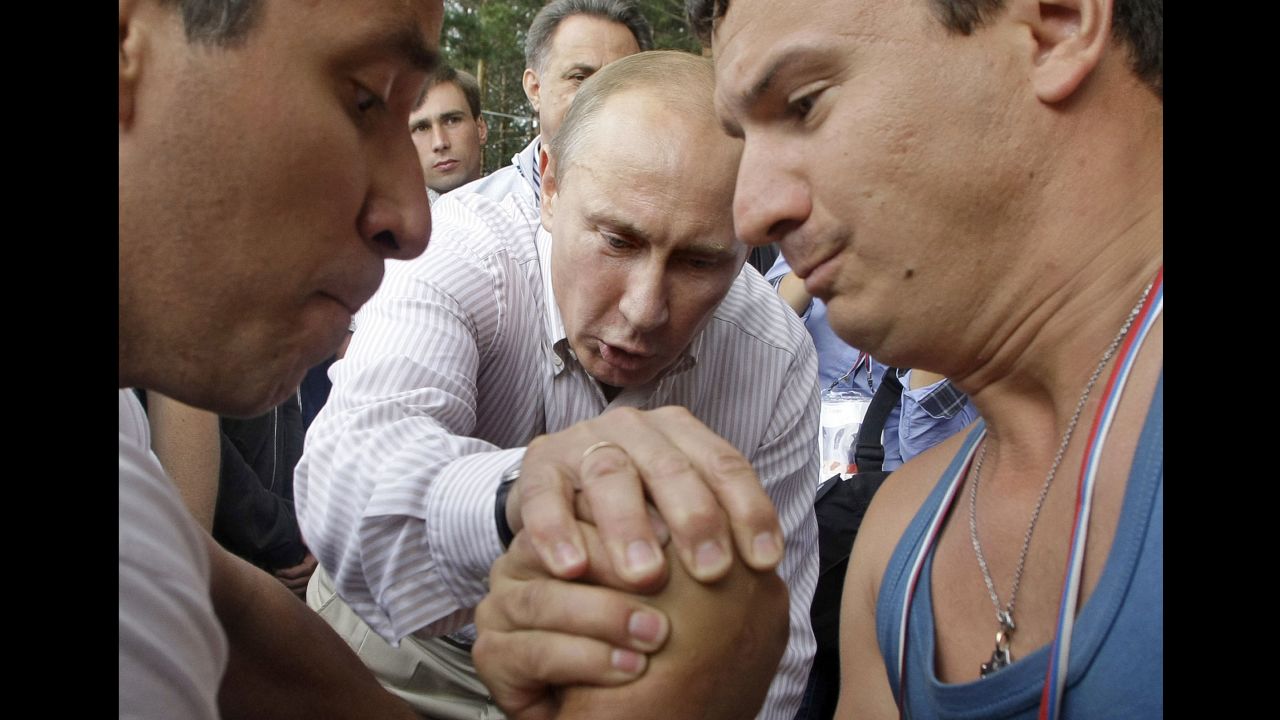 Putin officiates an arm-wrestling contest as he visits a youth educational forum near Russia's Lake Seliger in August 2011.