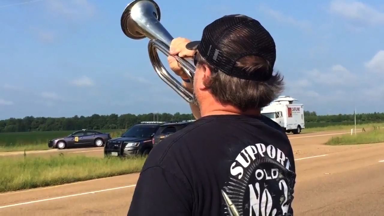 David Weeks, of Inverness, Mississippi, plays taps Tuesday near the crash site.