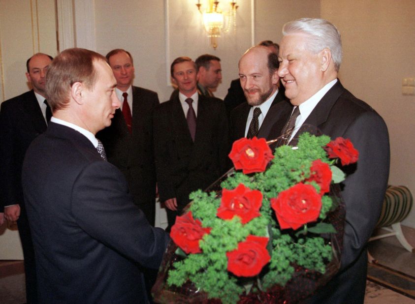 Putin rose quickly through the political ranks. Here, he gives flowers to Russian President Boris Yeltsin during a farewell ceremony in Moscow in December 1999. Yeltsin, Russia's first democratically elected president, was resigning from office. Putin, his prime minister, was appointed acting president until the election, which Putin won several months later.
