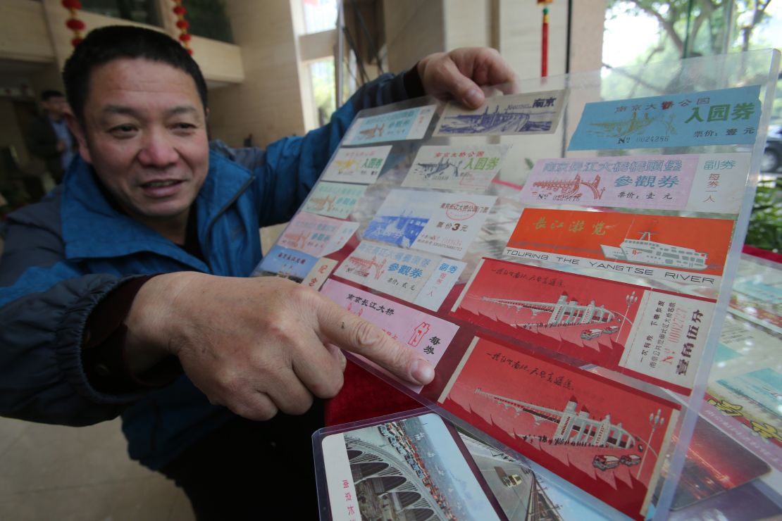 Wang Shiqing is pictured with railway tickets featuring illustrations of the bridge, part of his vast collection.