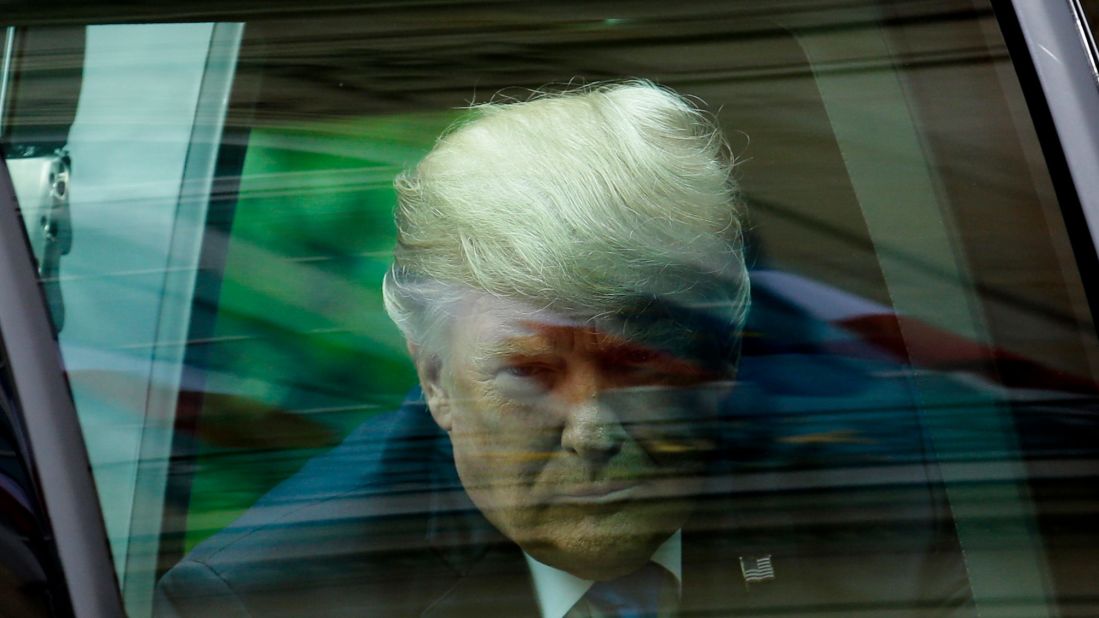 Trump exits his car as he arrives for the meeting in Paris.