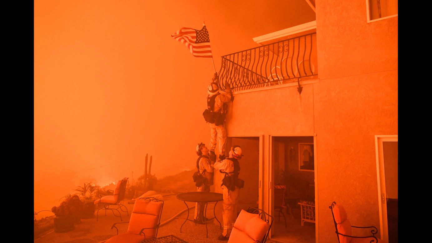 Firefighters <a href="http://www.cnn.com/2017/07/10/us/california-wildfires-firefighter-photo-trnd/index.html" target="_blank">remove an American flag</a> as a wildfire closes in on a home in Oroville, California, on Saturday, July 8. Raging wildfires have forced thousands of people to evacuate their homes across the Western United States.