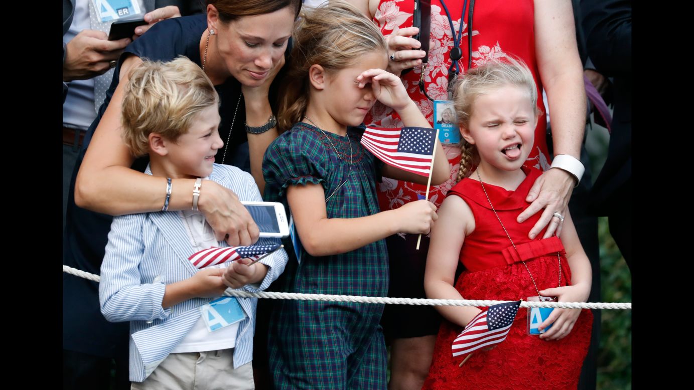 Children react to the rotor wash of the President's helicopter as it lands at the White House on Wednesday, July 12.