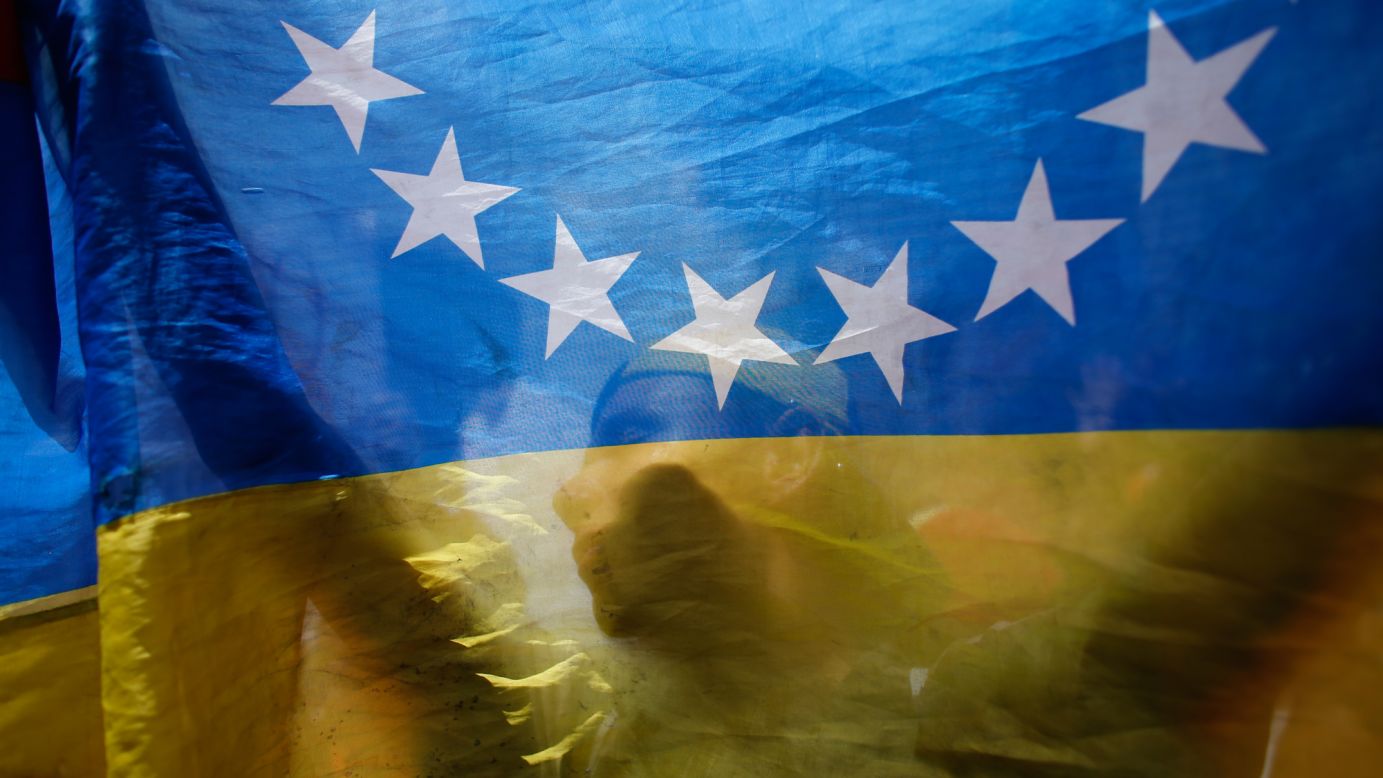 An anti-government demonstrator is seen behind a Venezuelan flag during a protest in Caracas, Venezuela, on Sunday, July 9. Venezuela <a href="http://www.cnn.com/2017/04/12/world/gallery/venezuela-protests/index.html" target="_blank">has seen widespread unrest</a> since March 29, when the Supreme Court dissolved Parliament and transferred all legislative powers to itself. The decision was later reversed, but protests have continued across the country.