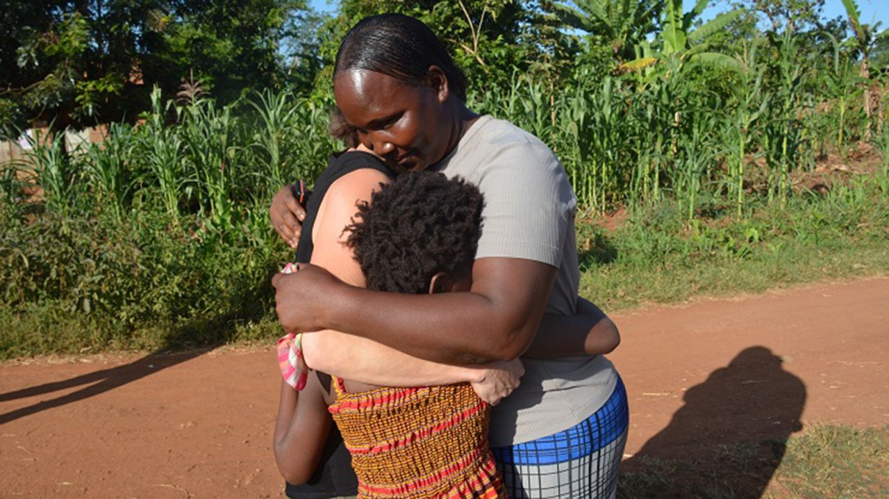 Violah's mother embraces her daughter and Stacey Wells, the woman who adopted Violah and then returned the girl to her Ugandan village. "I'm very happy and very grateful," Violah's mother said.<br />