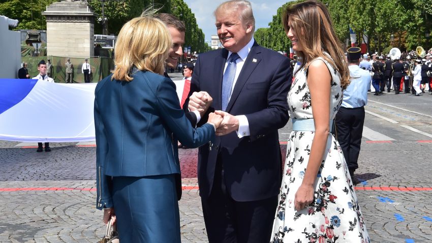 US President Donald Trump (2nd R) shakes hands with French President Emmanuel Macron (2nd L) and his wife Brigitte Macron (L), next to US First Lady Melania Trump, during the annual Bastille Day military parade on the Champs-Elysees avenue in Paris on July 14, 2017.
The parade on Paris's Champs-Elysees will commemorate the centenary of the US entering WWI and will feature horses, helicopters, planes and troops. / AFP PHOTO / POOL AND AFP PHOTO / CHRISTOPHE ARCHAMBAULT        (Photo credit should read CHRISTOPHE ARCHAMBAULT/AFP/Getty Images)