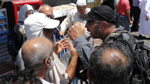 An Israeli security forces member argues Friday with Palestinians outside Jerusalem's Damascus Gate.