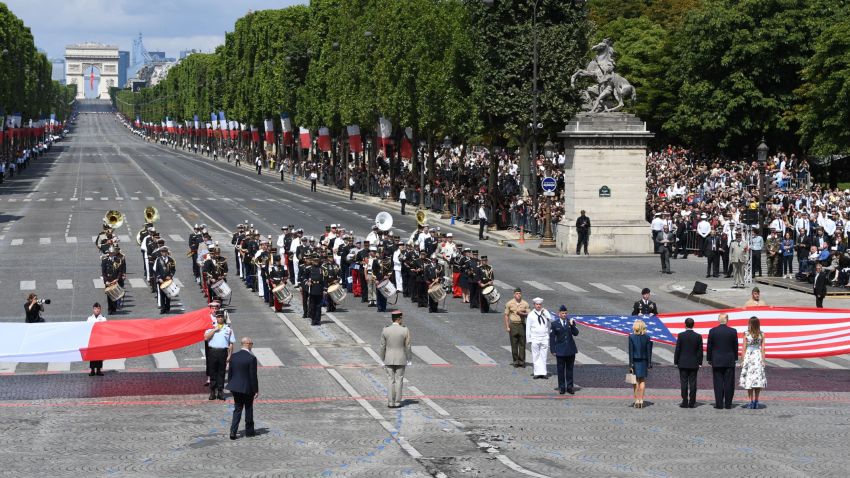 (RtoL) US First Lady Melania Trump, US President Donald Trump, French President Emmanuel Macron and his wife Brigitte Macron, walk towards the US national flag held by soldiers, as a French joint-army brass band performs, at the end of the annual Bastille Day military parade on the Champs-Elysees avenue in Paris on July 14, 2017.
The parade on Paris's Champs-Elysees will commemorate the centenary of the US entering WWI and will feature horses, helicopters, planes and troops. / AFP PHOTO / ALAIN JOCARD (Photo credit should read ALAIN JOCARD/AFP/Getty Images)