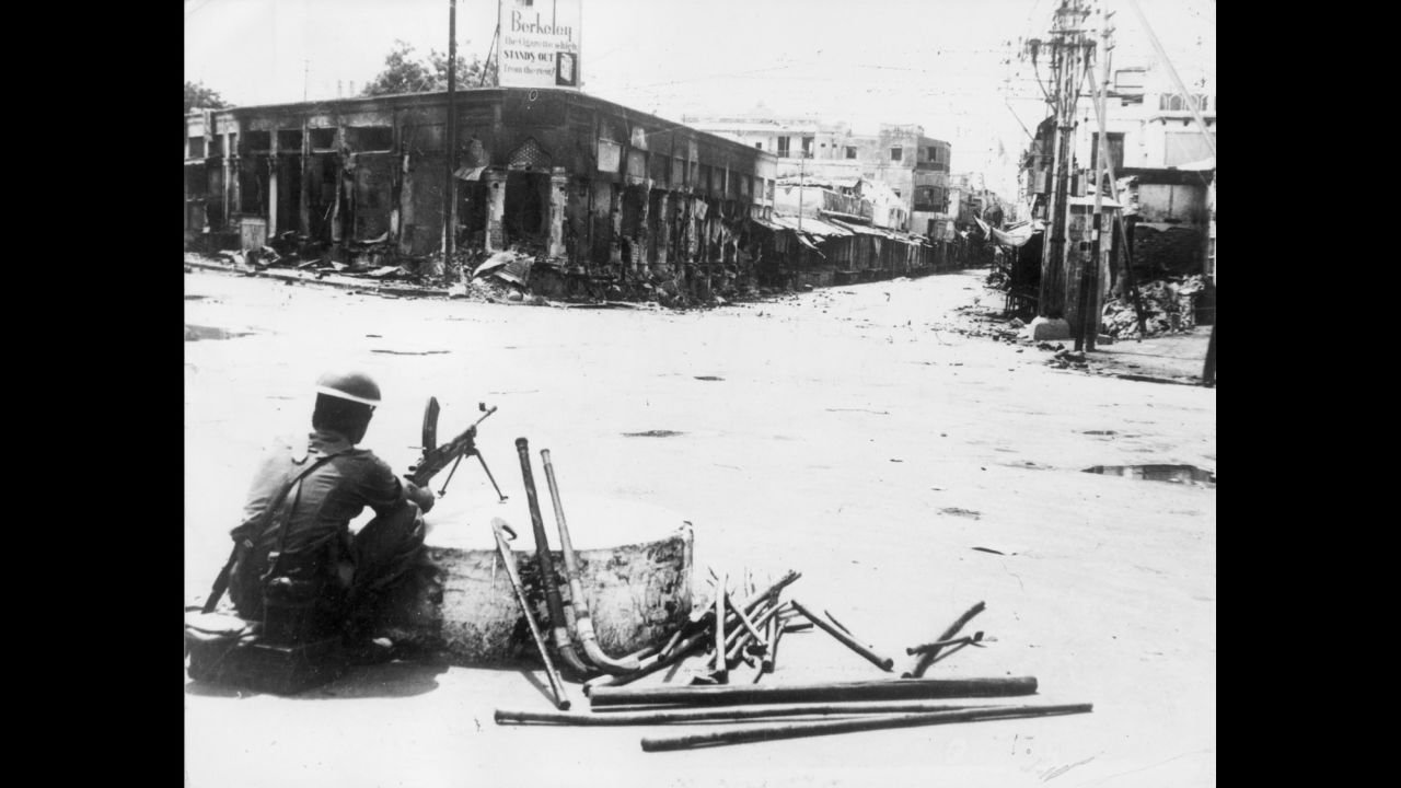  During intense rioting, a soldier sits with a Bren light machine gun at the entrance to Paharganj bazaar, New Delhi, on September 16, 1947. 