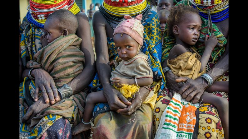 Families wait for malnourished children to be weighed and measured at a health clinic in Kenya. 