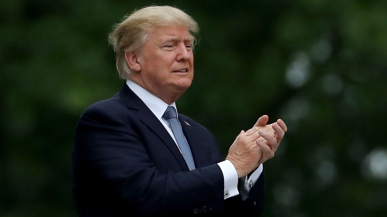 U.S. President Donald Trump acknowledges the patrons in the clubhouse as he leaves the U.S. Women's Open round two on July 14, 2017 at Trump National Golf Course in Bedminster, New Jersey.