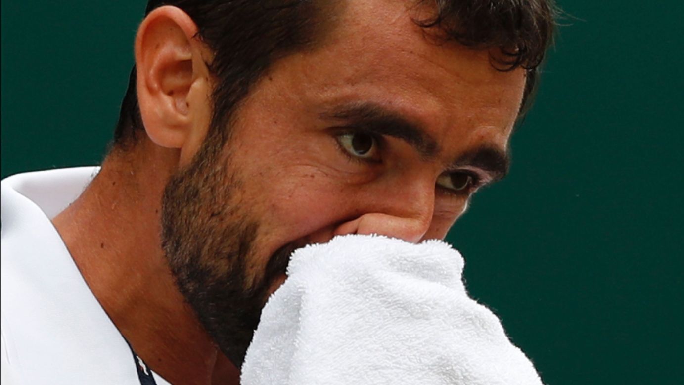 Cilic wipes his face with a towel during his match with Federer.