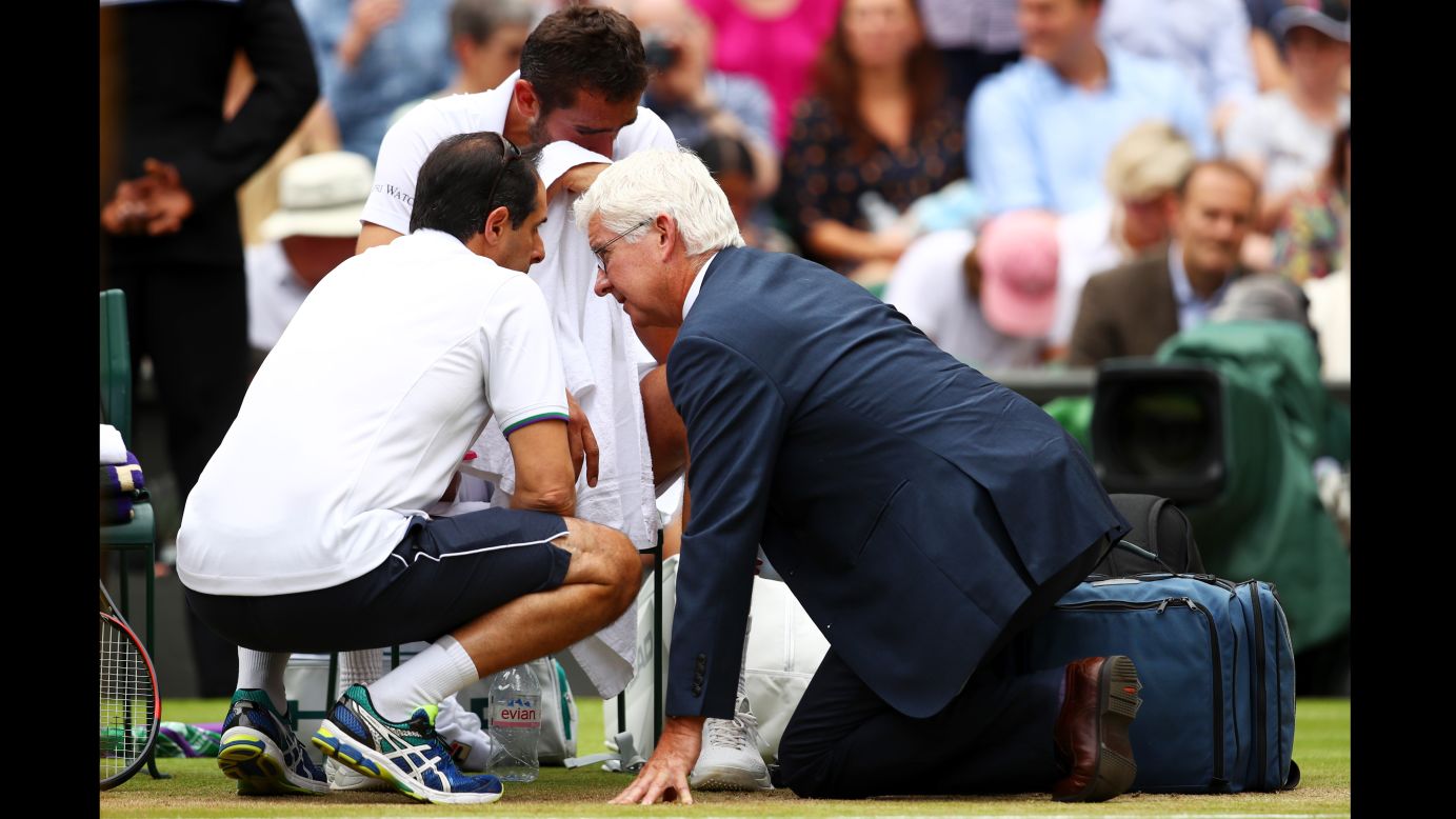 An emotional Cilic receives assistance during his loss to Federer.